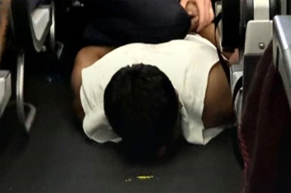 Man lays face down on airplane