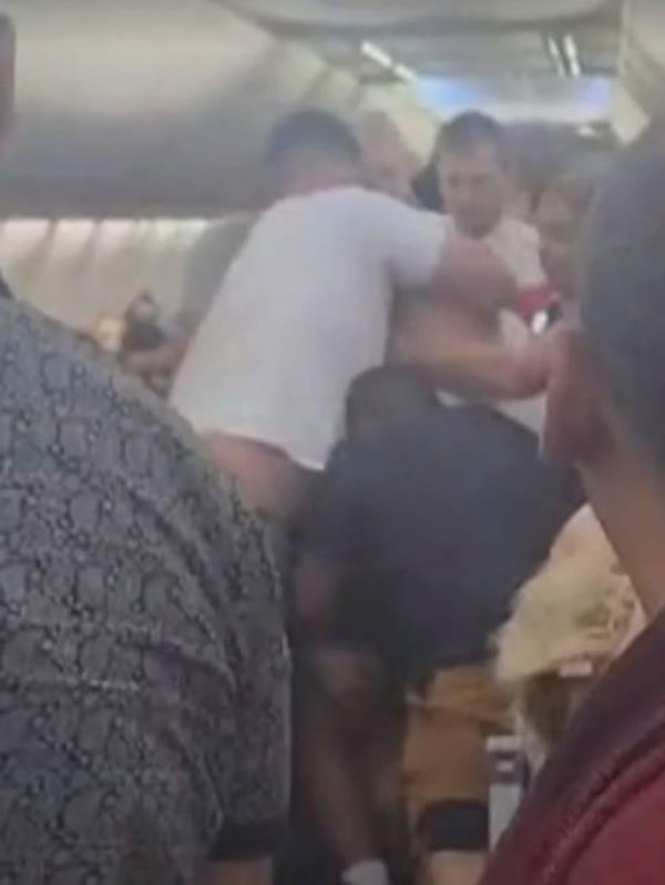 Passengers wrestling man down on airplane