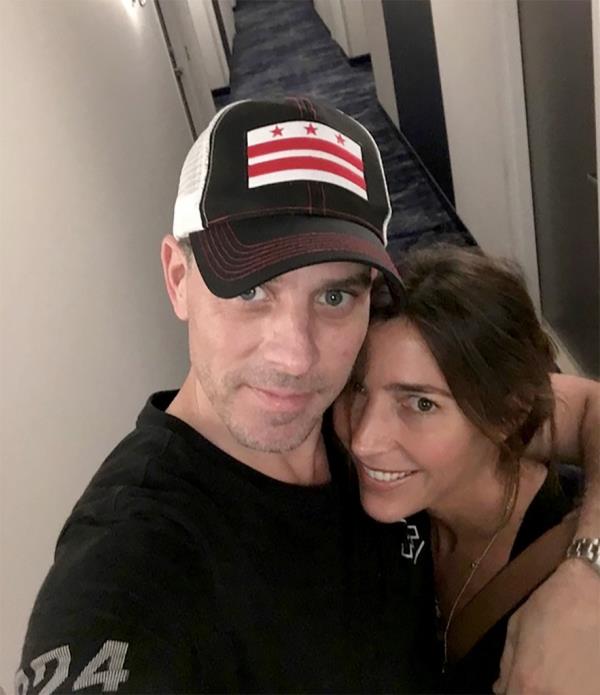 Hunter in a ba<em></em>seball cap with his arm around and Hallie Biden