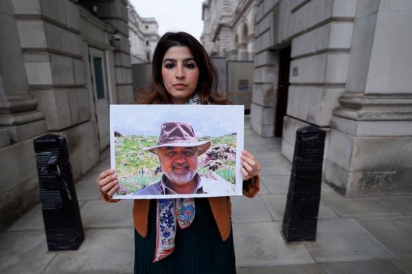 Roxanne Tahbaz holds a picture of her father Morad Tahbaz who is jailed in Iran, during a protest outside the Foreign, Commo<em></em>nwealth and Development Office in London, April 13, 2022.