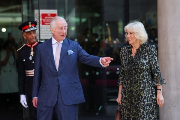 Britain's King Charles and Queen Camilla walking and waving to crowds during their visit to the University College Hospital Macmillan Cancer Centre in London