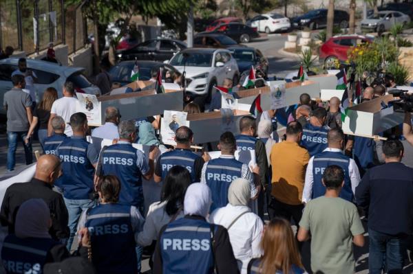 Palestinian journalists carry mock coffins of Palestinian journalists who were killed in the war with Israel.