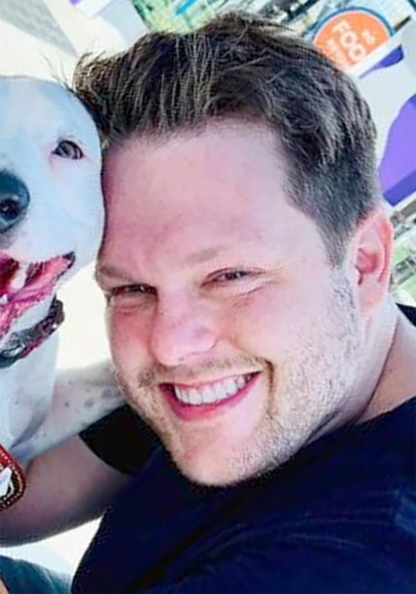 A photo of Jordan Willis posing with one of his two rescue dogs,