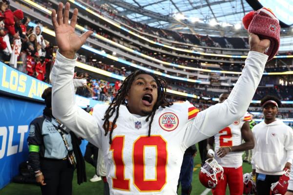 Isiah Pacheco #10 of the Kansas City Chiefs celebrates as he leaves the field after a game against the Los Angeles Chargers at SoFi Stadium. He is followed by other team members.