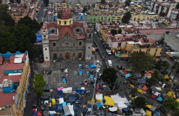 Aerial view of migrant tent encampment at the plaza of the Santa Cruz y La Soledad Catholic parish church in La Merced neighborhood of Mexico City
