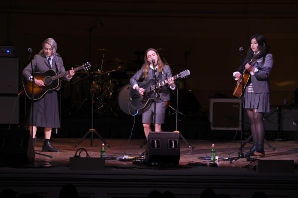 Phoebe Bridgers, Julien Baker, and Lucy Dacus of Boygenuis on stage performing, 