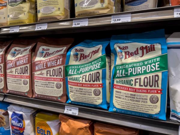 Bags of Bob's Red Mill brand flour for sale on store shelf.