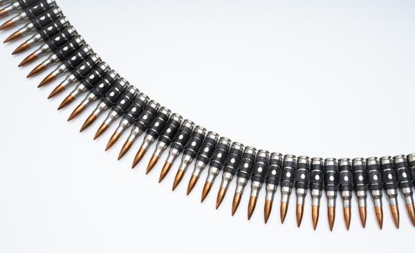 Ammo belt full of bullets displayed on a white surface
