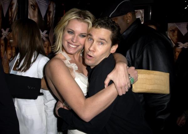 Rebecca Romijn with Bryan Singer, hugging and smiling. 