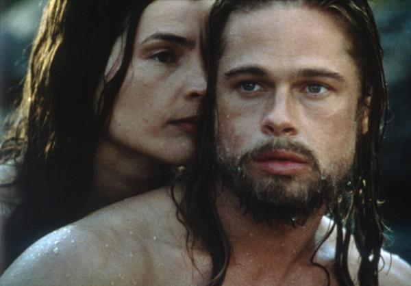Julia Ormond and Brad Pitt sitting together in Legends of the Fall movie scene.