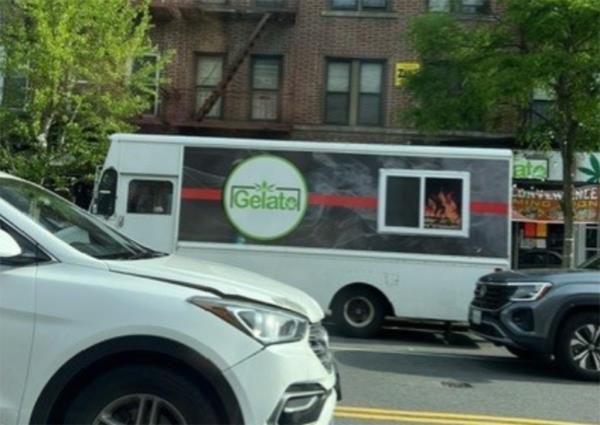 A white truck with a green logo, used as a mobile cannabis shop, parked on 86th Street in Brooklyn.