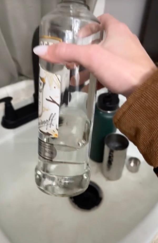 Mary holding up the vodka bottle.