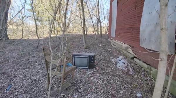 A vintage television set in the backyard. 