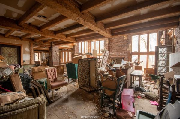 A room with peeling wallpaper and stuff everywher<em></em>e