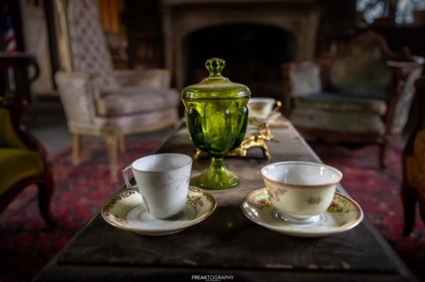 Vintage tea cups are seen perfectly situated on a table.