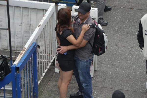 A man and woman embrace on the street near brothels at the intersection of Roosevelt Avenue and 89th Street on Sept. 1, 2024.