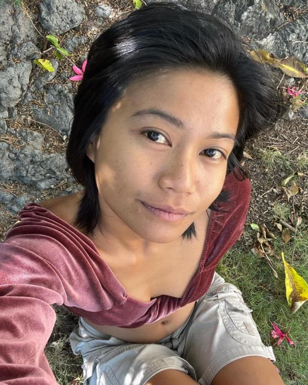 Ariana Ursua in a pink velvet crop top and shorts taking a selfie.