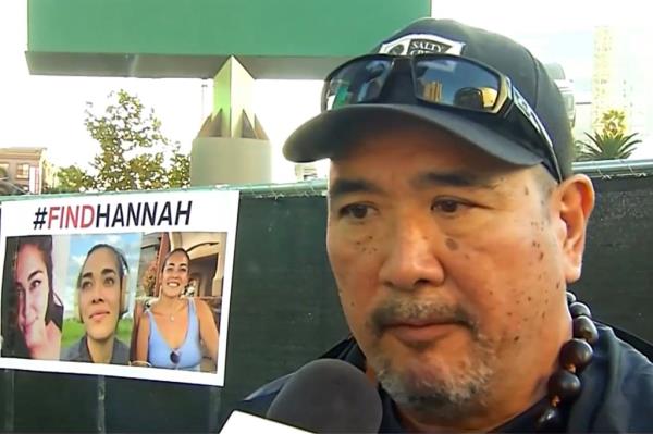 Ryan Kobayashi, wearing a cap and sunglasses, speaking into a microphone, during search for his missing daughter, Hannah Kobayashi