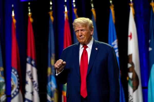 Trump raises his fist as he greets the crowd before speaking during the Natio<em></em>nal Guard Association of the United States' 146th General Conference.