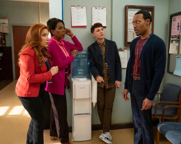 A group of people, including Lisa Ann Walter, Sheryl Lee Ralph, Chris Perfetti, and Tyler James Williams, standing in a room at Abbott Elementary during Career Day event