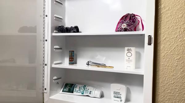 A minimalist lifestyle, represented by a white shelf with few items, allowing substantial saving despite living in an expensive city.