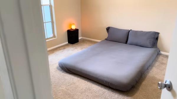 A minimalist's small bedroom with bare essentials in an expensive city