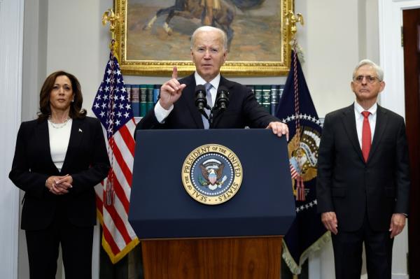 U.S. President Joe Biden, Vice President Kamala Harris, and Attorney General Merrick Garland standing together, with Biden addressing the assassination attempt on former President Do<em></em>nald Trump from a podium.