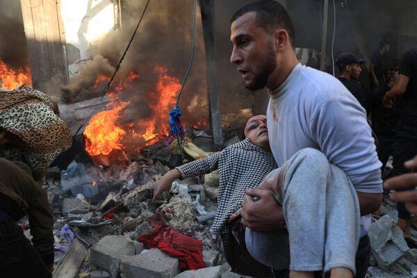 A man evacuates a wounded girl after Israeli bombardment in Rafah in the southern Gaza Strip on November 17, 2023, amid o<em></em>ngoing battles between Israel and the Palestinian group Hamas. Photo: Said Khatib / AFP via Getty Images.