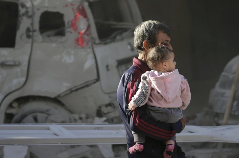 A Palestinian carrying his daughter, walks next to the rubble in a destroyed area following an Israeli airstrike in Deir Al-Balah, southern Gaza Strip, Palestine, Jan. 7, 2024. (EPA Photo)